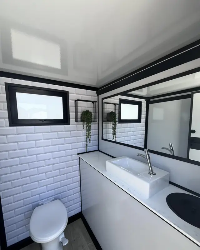 Restroom trailer room with white tile walls, a sink and a toilet